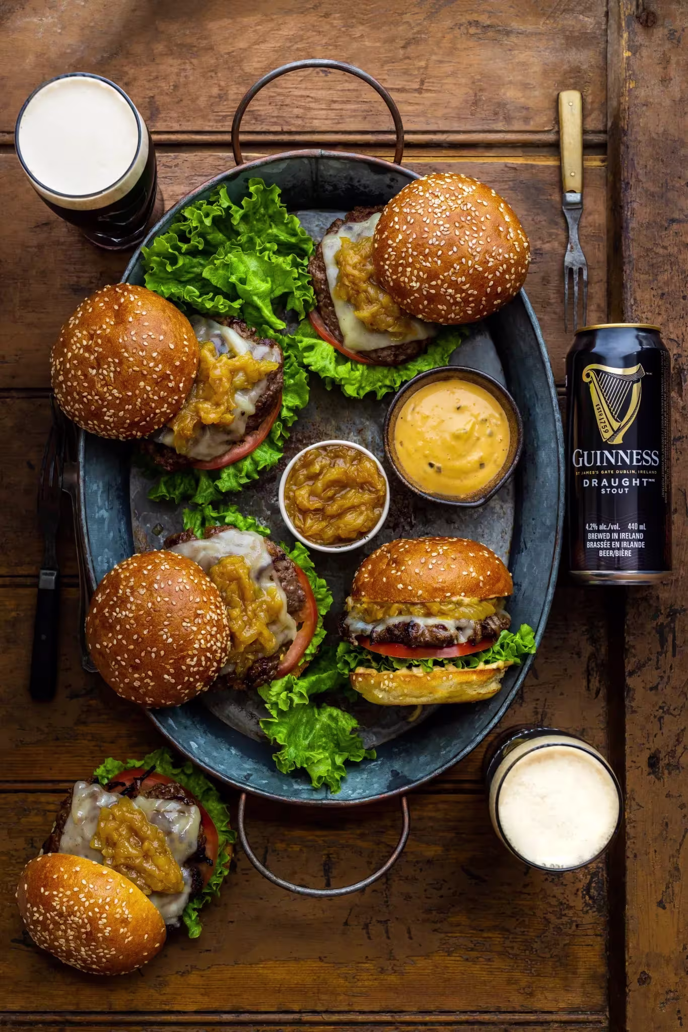 arafed burgers and beer on a plate with a beer