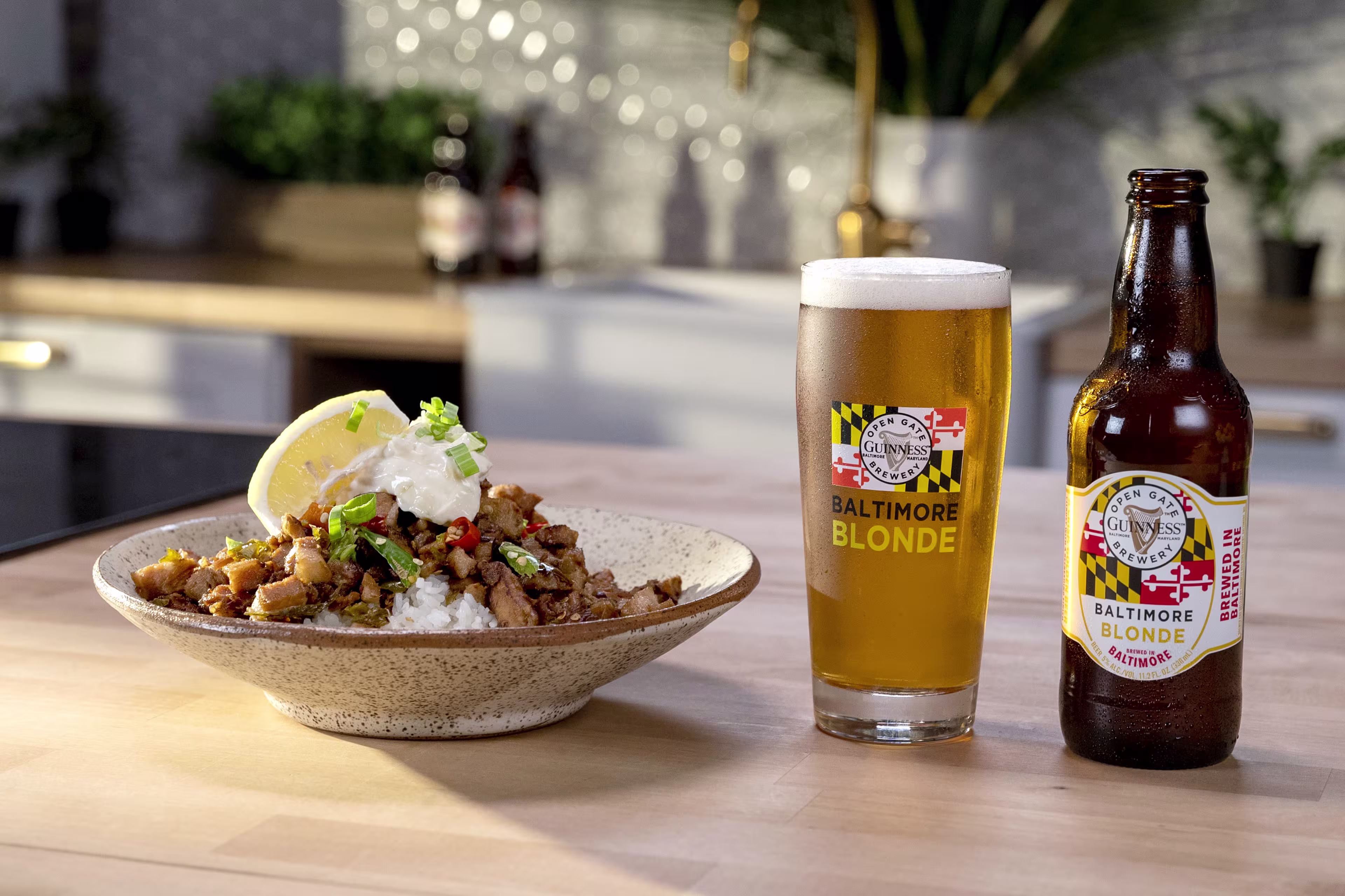 there is a bowl of food and a beer on a table