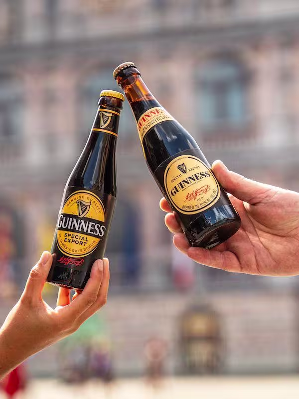 2 bottles of Guinness held in hands