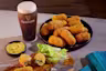 there are some food on a plate and a glass of beer