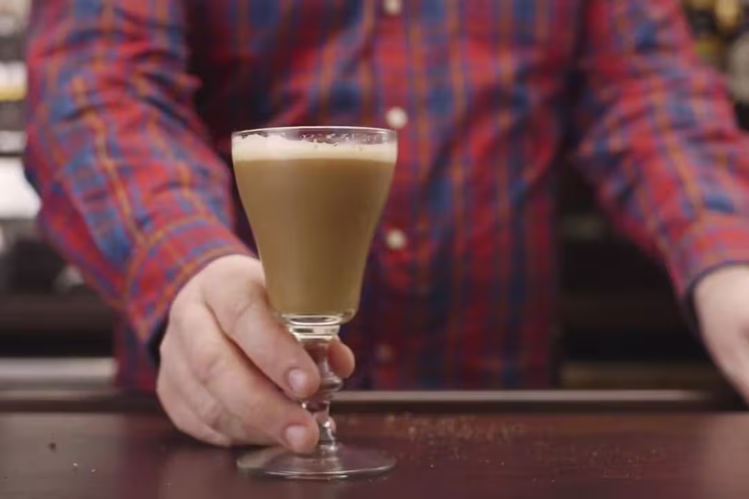 a close up of a person holding a glass of coffee