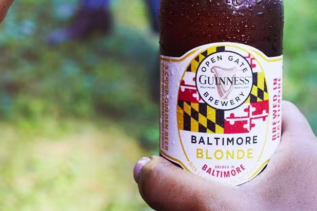 Guinness Baltimore Blonde bottle in hand.