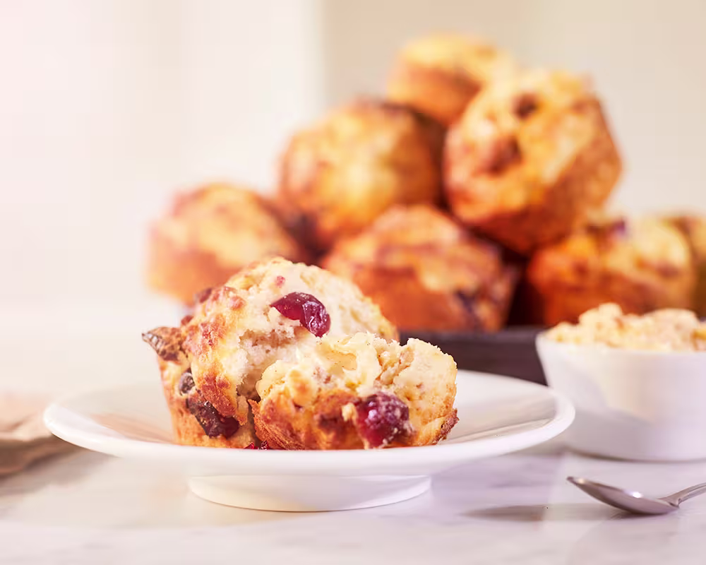 there is a muffin on a plate with a bowl of cereal