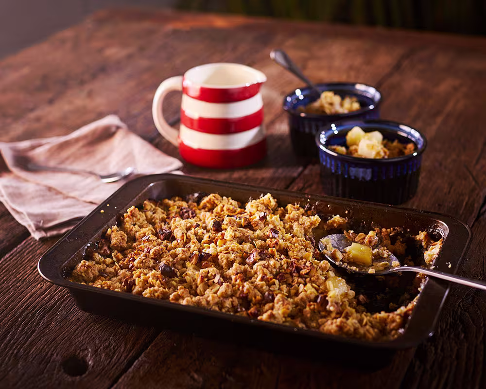 there is a pan of food on a table with a cup of coffee