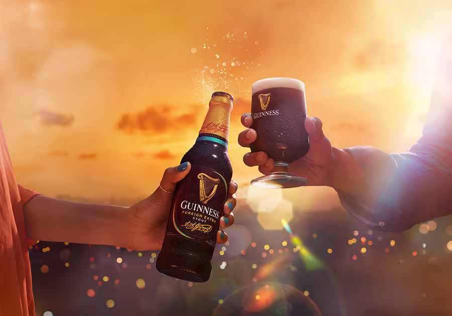 someone is holding a beer and a glass with a beer being poured