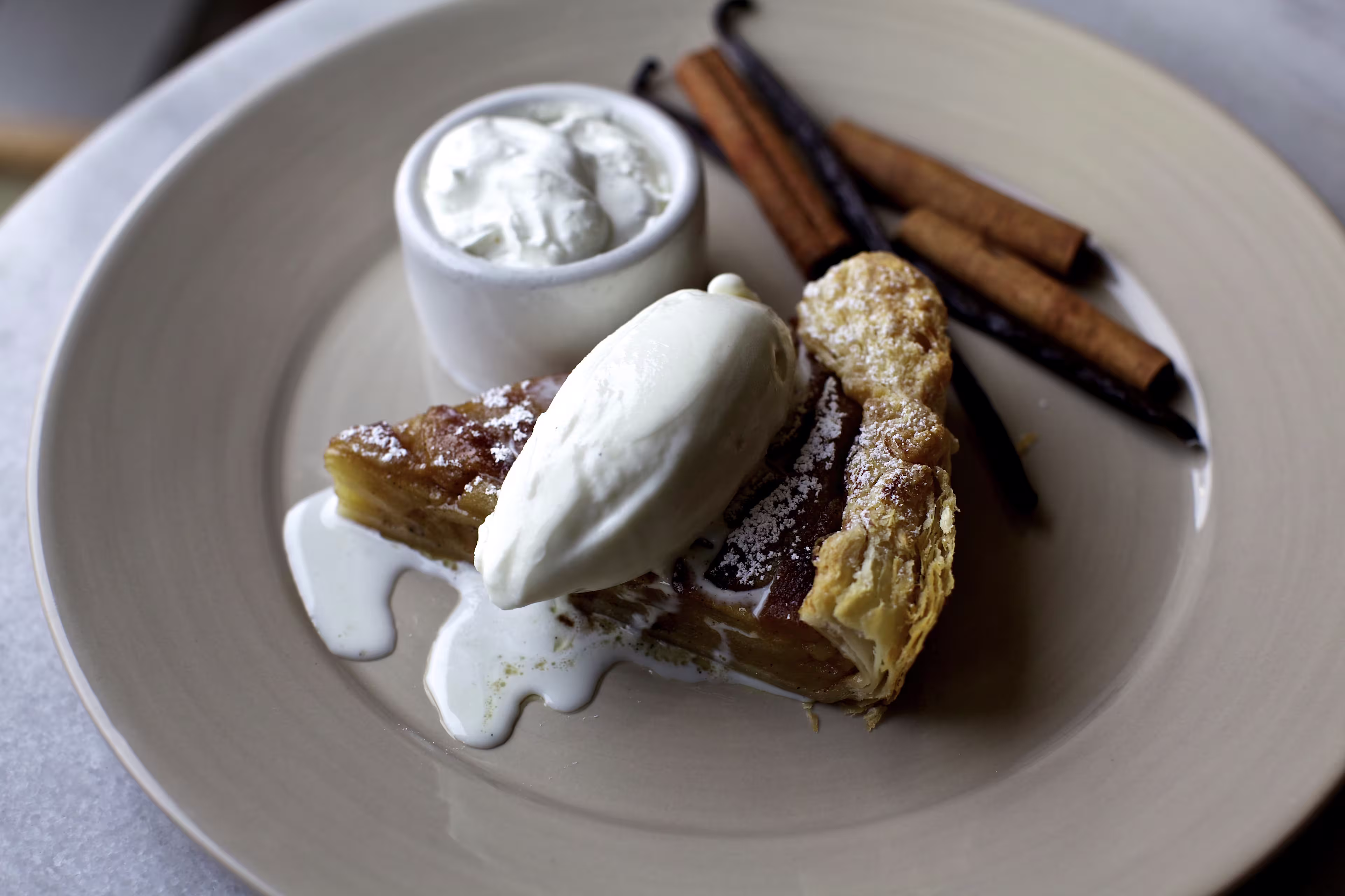 there is a piece of pie with ice cream and cinnamon sticks