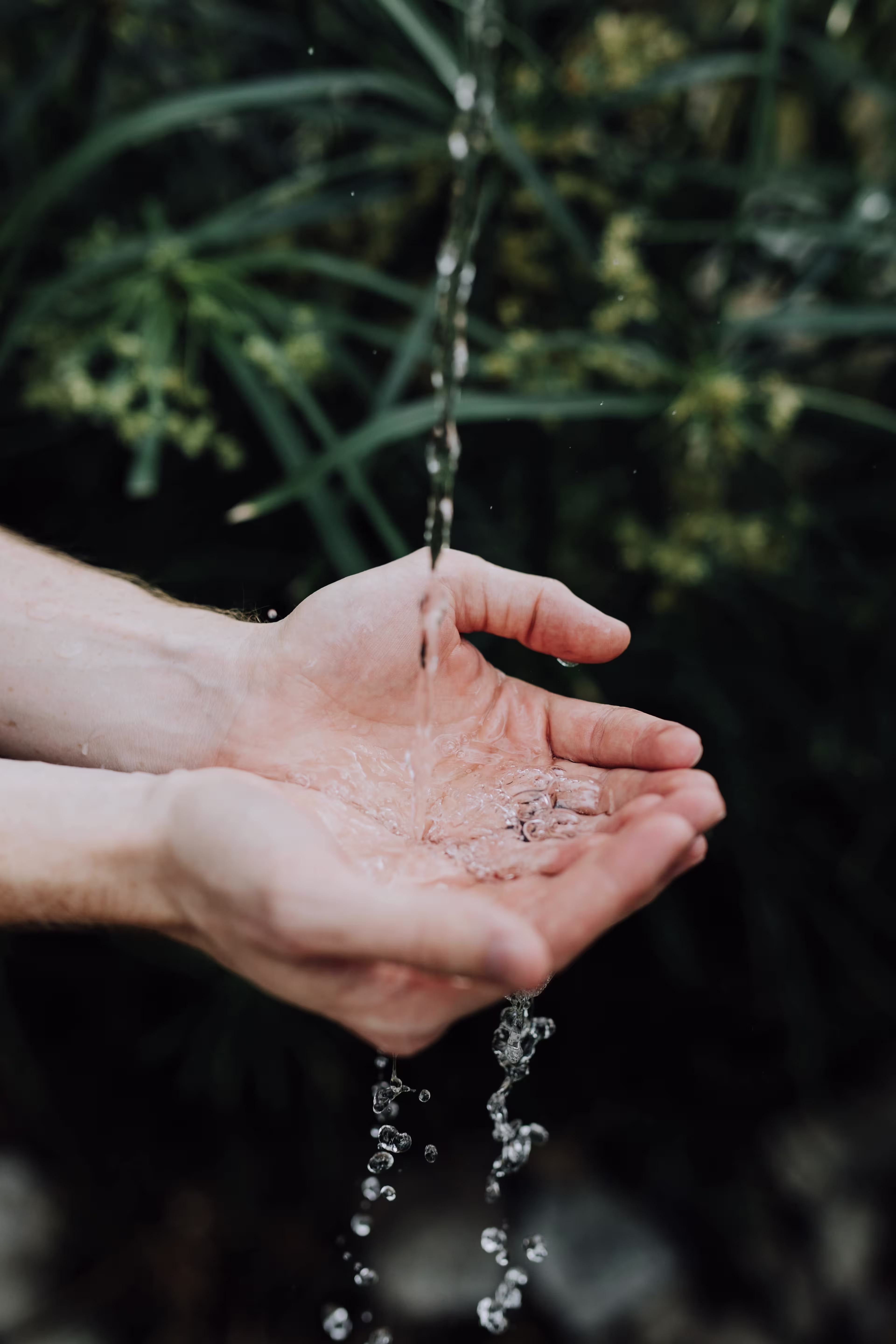someone is holding out their hand to a stream of water