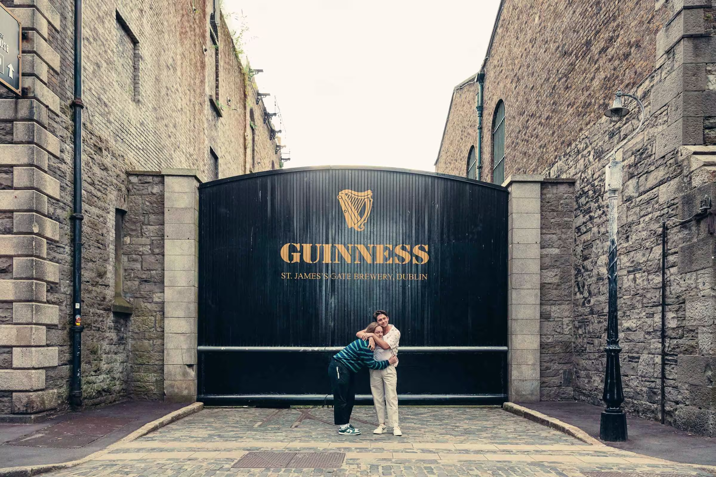 araffes standing in front of a guinness sign in a narrow alley
