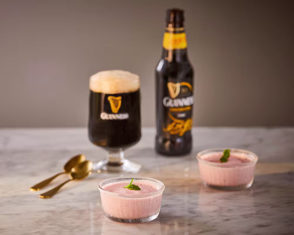 there are two cups of pudding and a bottle of beer on the table