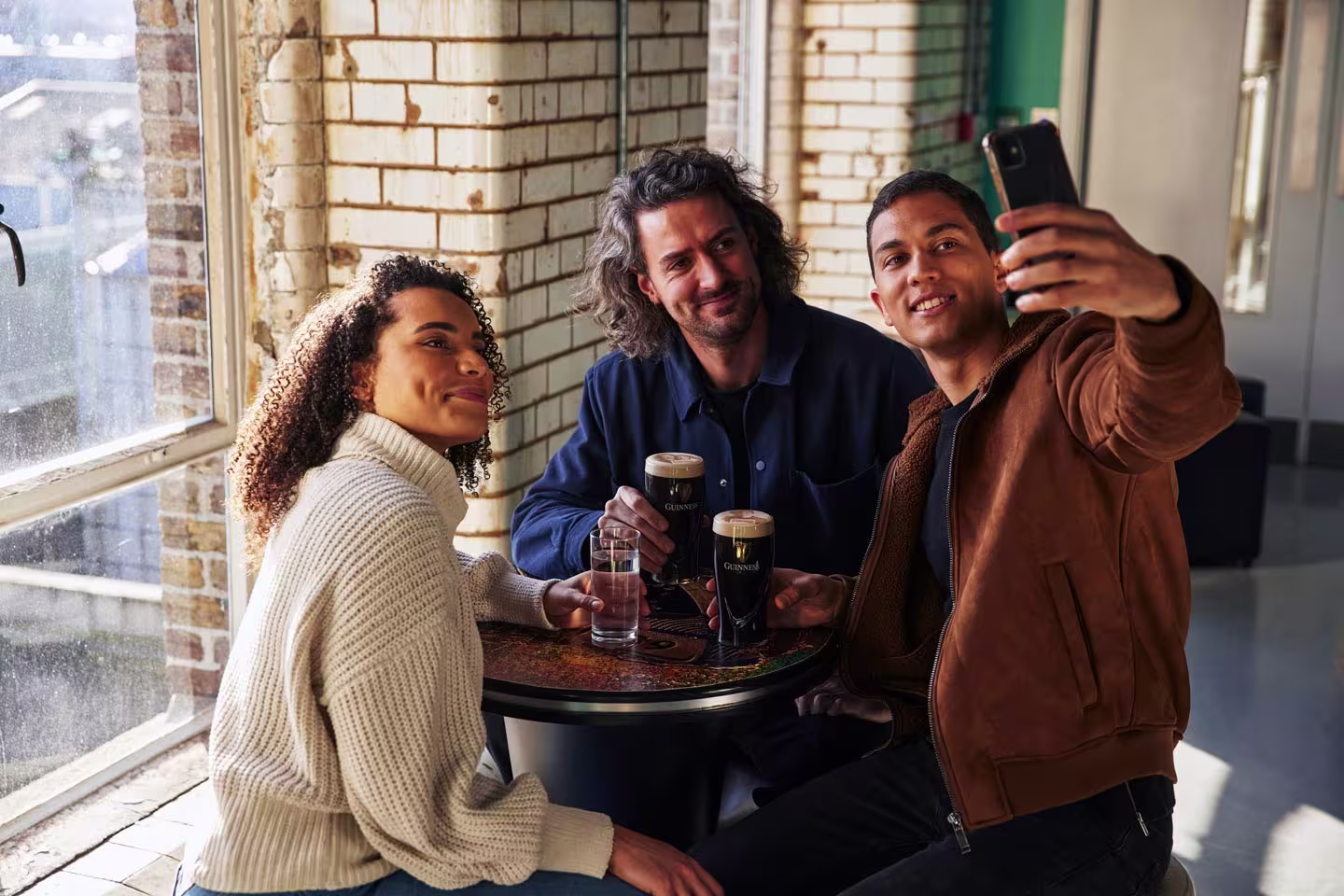 there are three people sitting at a table taking a picture