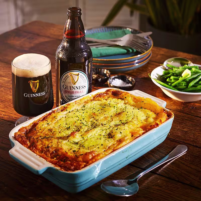 there is a casserole dish with cheese and vegetables on a table