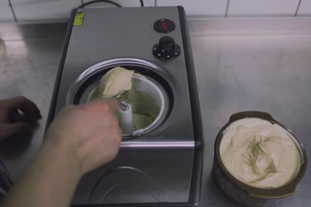 someone is making a cake with a blender in a kitchen