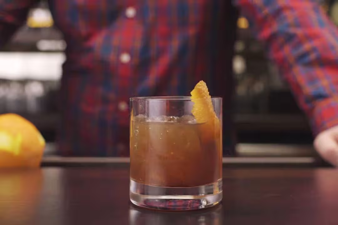 a close up of a person holding a glass of a drink