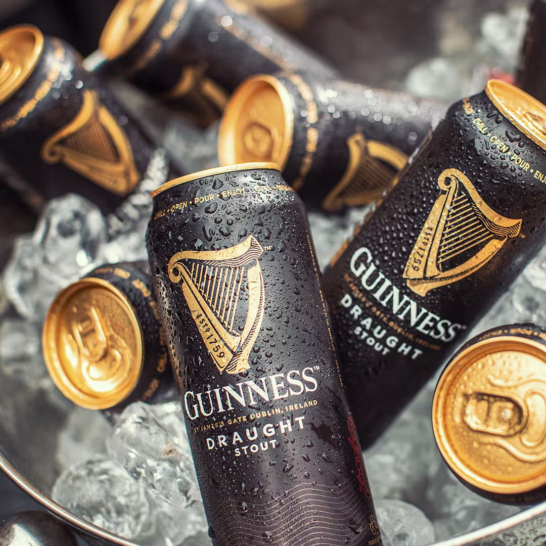 Cans of Guinness Draught Stout sitting on ice.