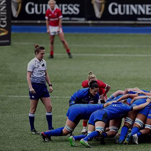arafed group of women in blue uniforms playing a game of rugby