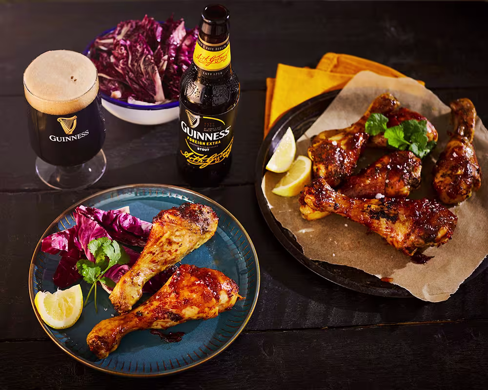there are two plates of food on a table with a beer