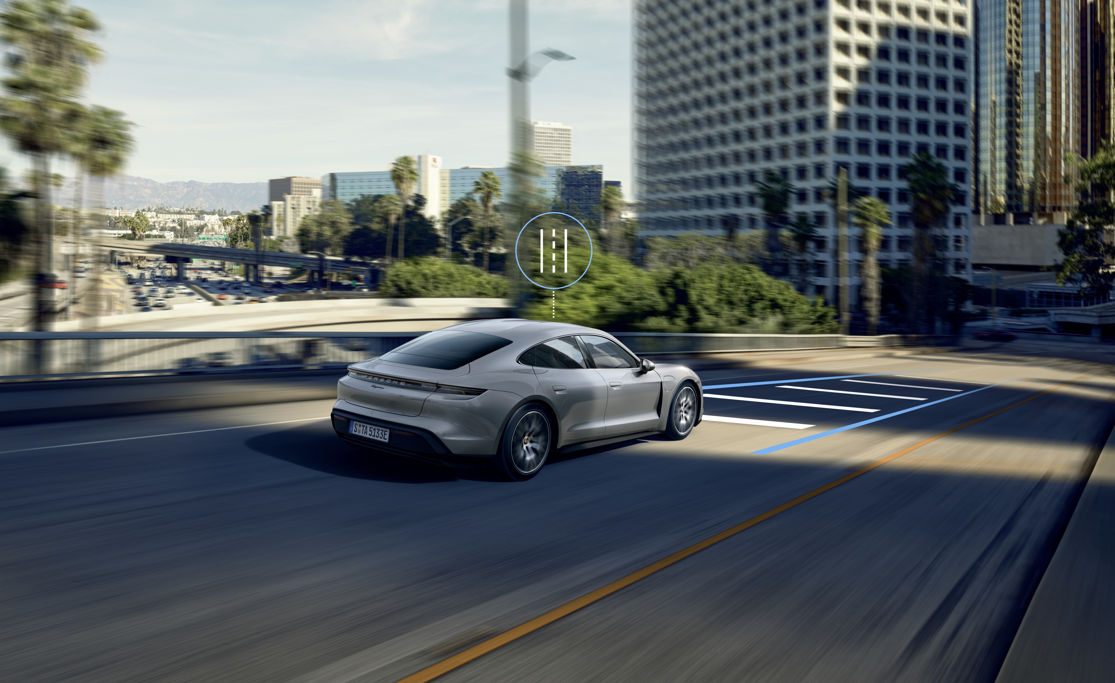 Grey Porsche Taycan driving along a road