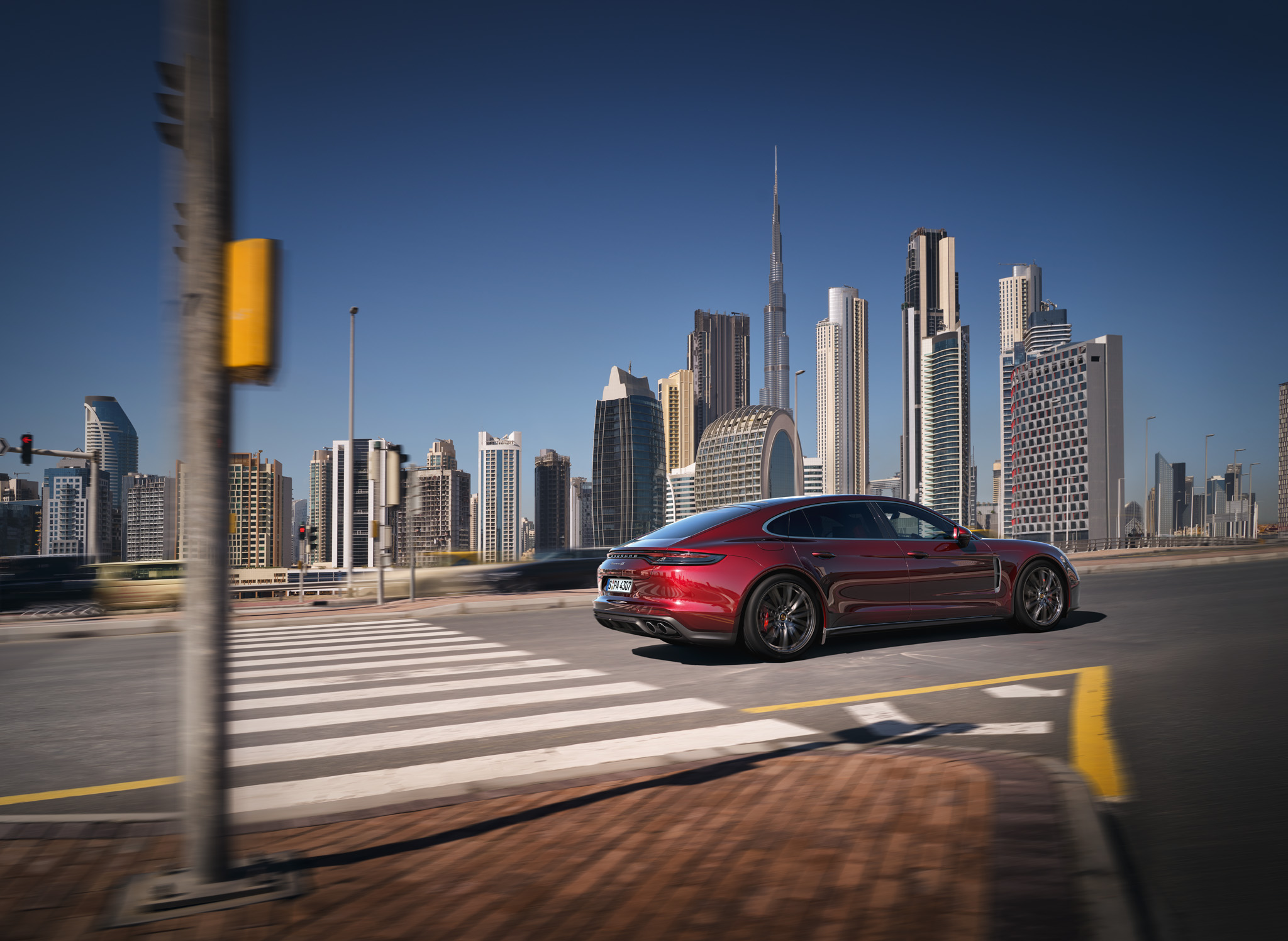 Red Porsche Panamera driving along a road 