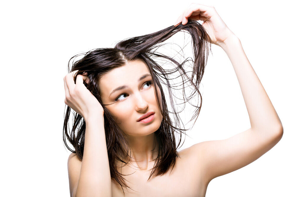 disappointed woman with hair loss looking at her hair strands