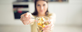 Woman holding up spoonful of cereal