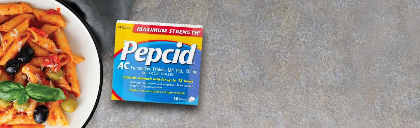 Box of Pepcid Maximum Strength AC placed next to a plate of pasta.
