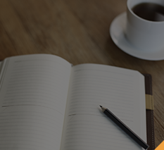 Notebook laying open on a desk with a cup of coffee