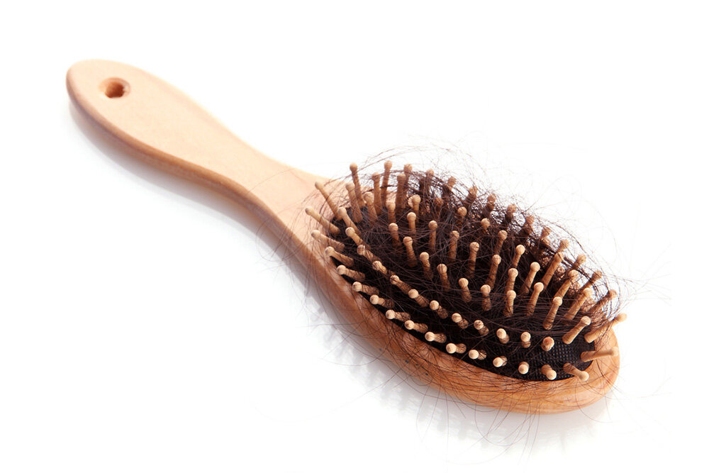 wooden hair brush with hair stuck inside