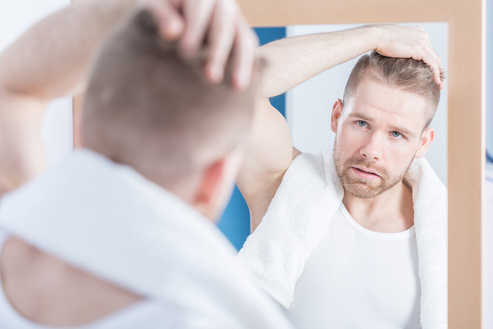 man applying ROGAINE® hair growth treatment