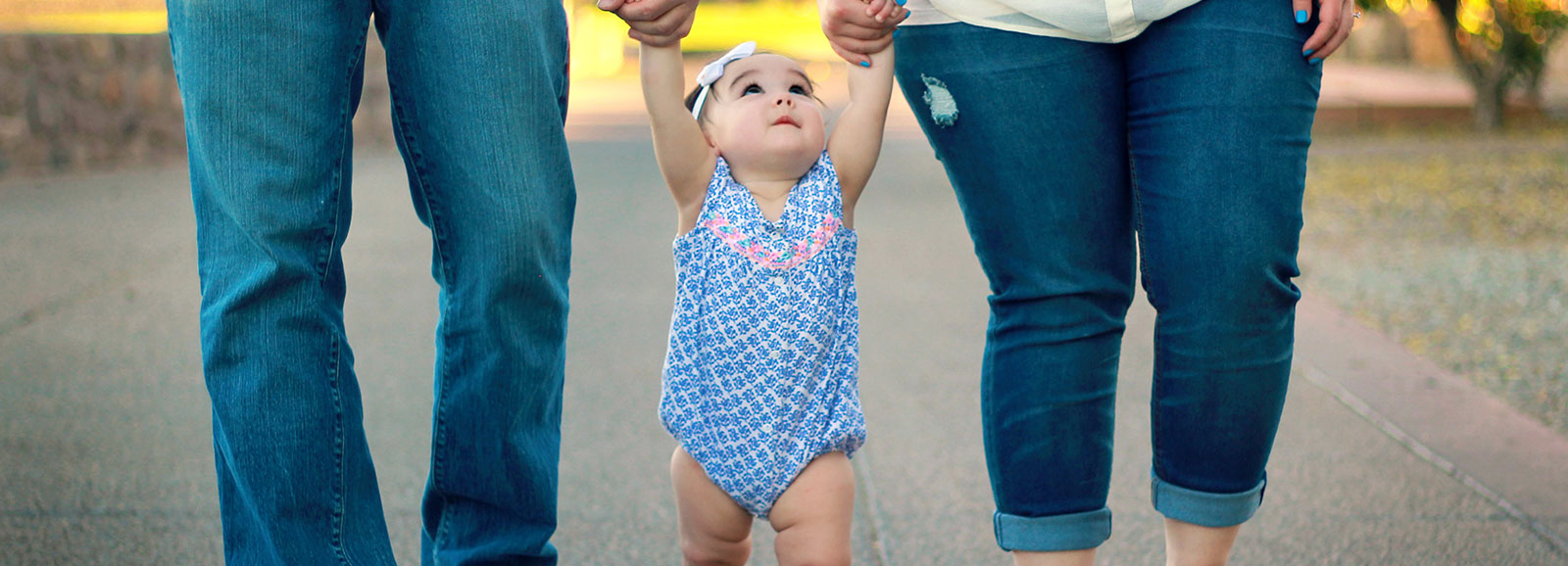 Bébé marchant entre ses deux parents