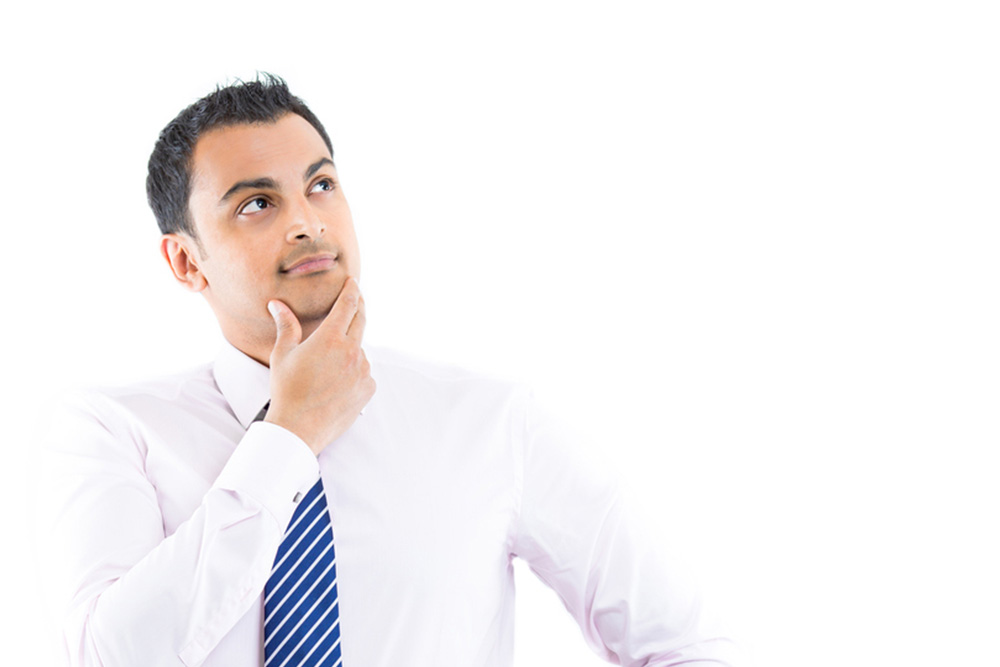 man in a dress shirt and blue tie thinking about hair loss myths