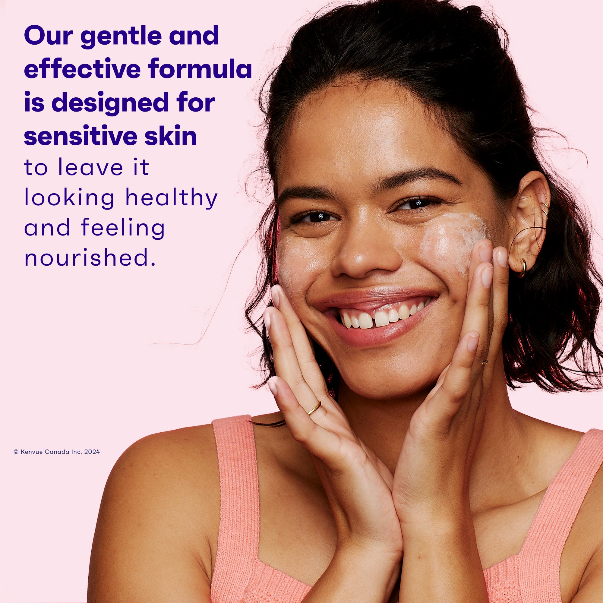 Young black woman using foaming cleanser on her face and smiling