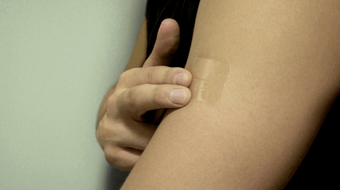 Person applying a nicotine patch on Nicoderm.ca