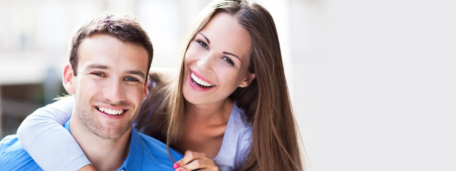 woman leaning over and hugging a man in a blue shirt