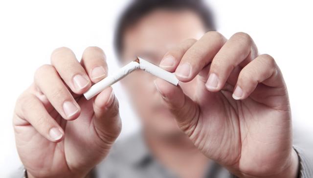 Un homme brisant une cigarette en deux