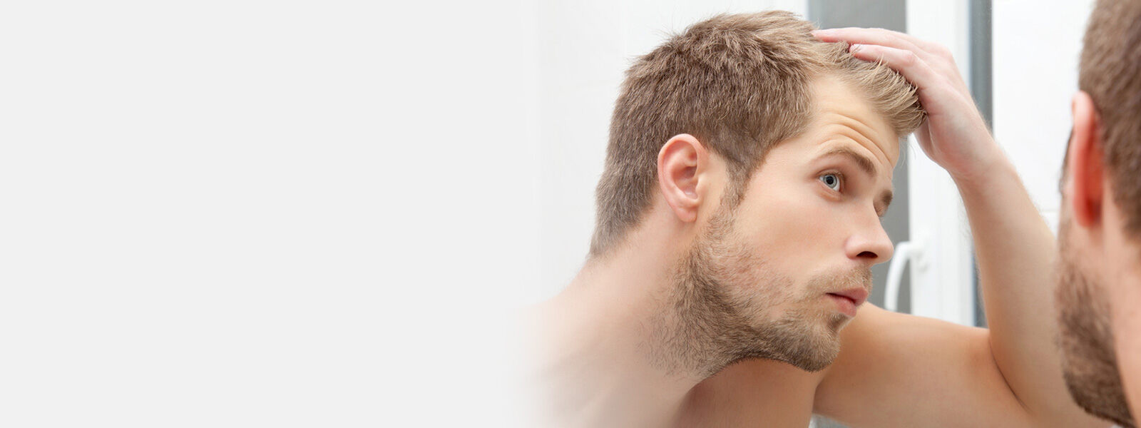 homme aux cheveux châtains qui se regarde dans un miroir