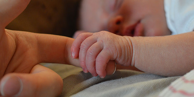 Baby holding parents finger