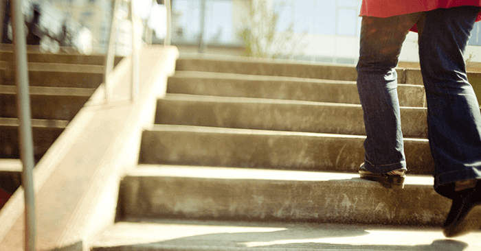 Person walking up outdoor concrete stairs on Nicoderm.ca