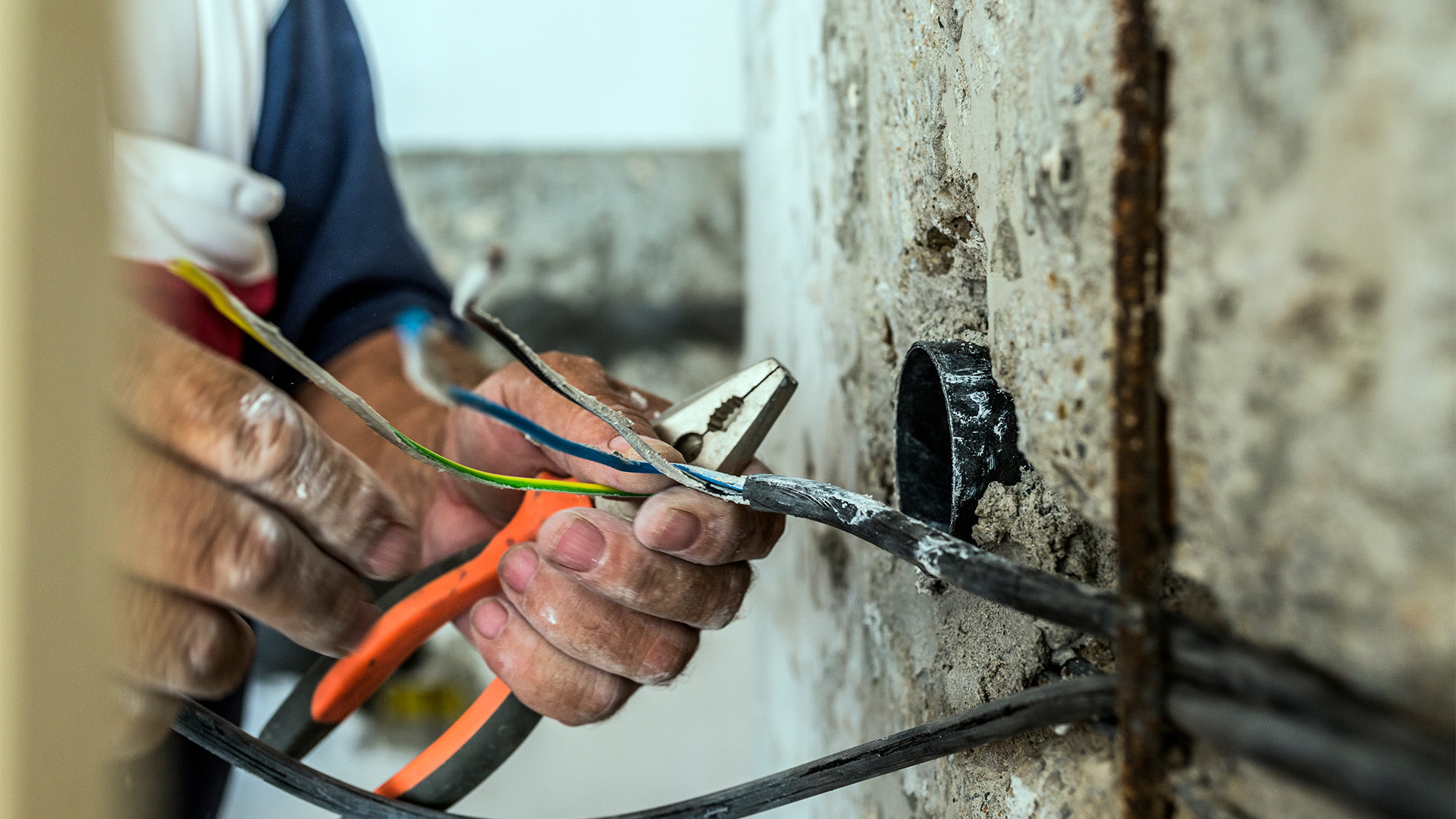 A person using pliers to cut wires