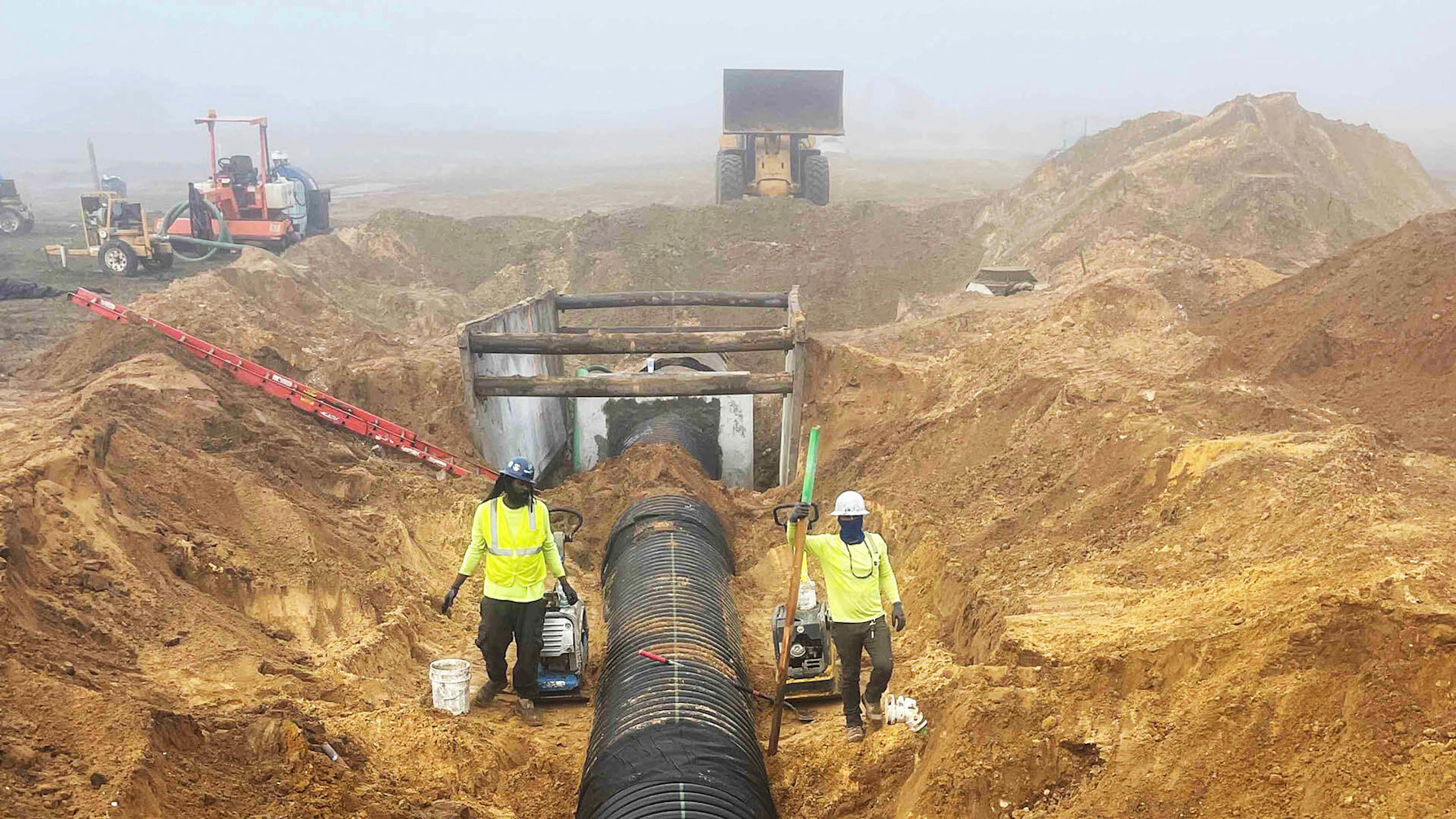 Construction workers installing a pipe system