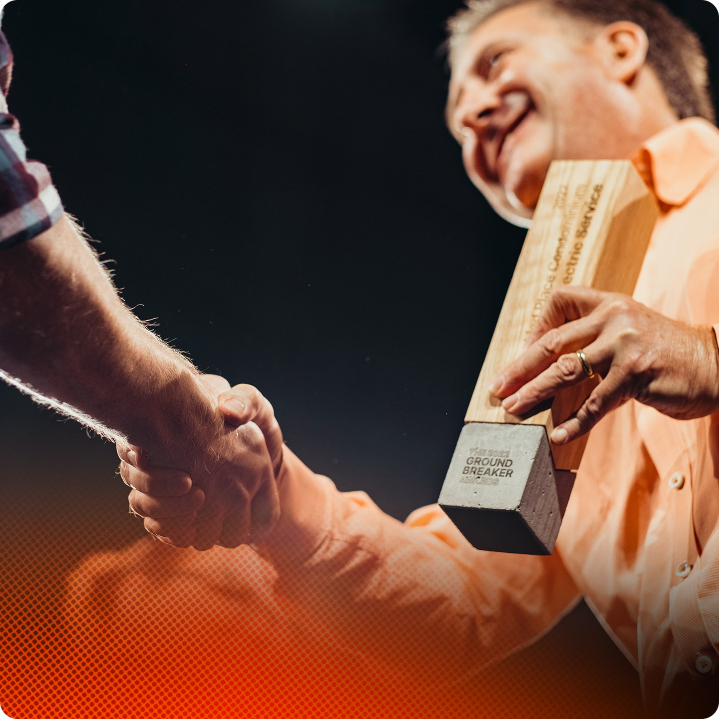 A man holding a groundbreaker award