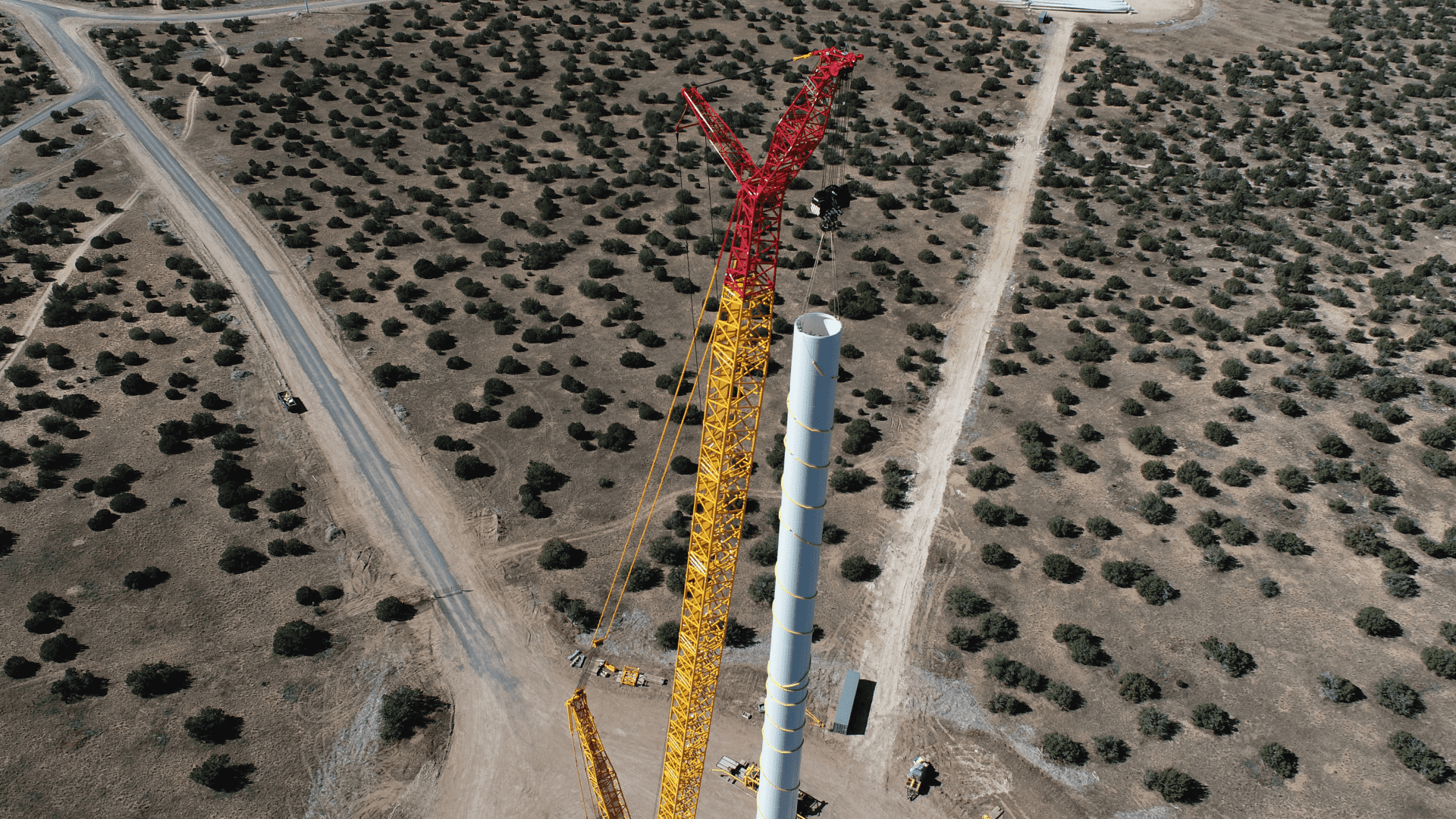 a crane and a tall tower in an empty construction site
