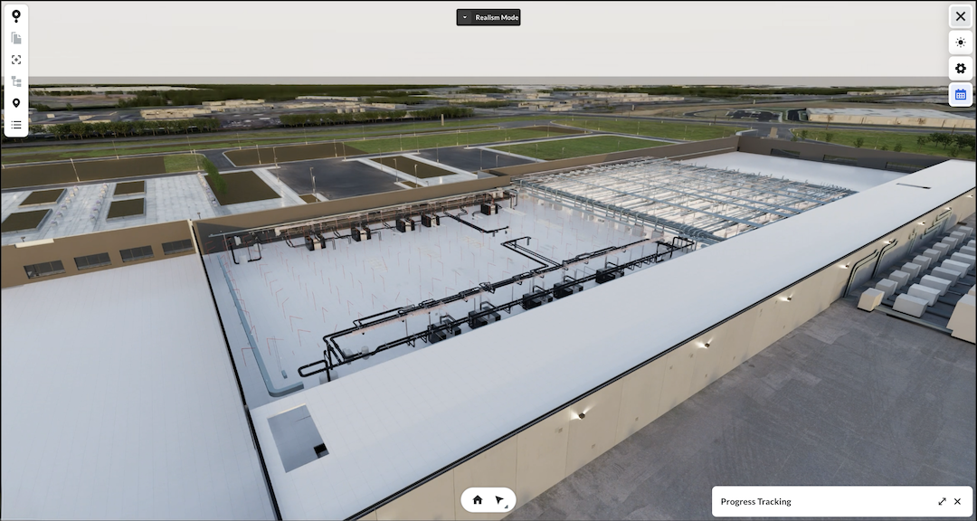 Aerial view of industrial facility with white roofed buildings, metal framework, and green fields in background.