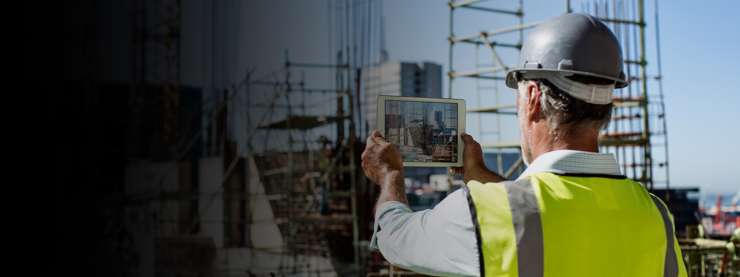 A man taking a picture of the construction with a tablet