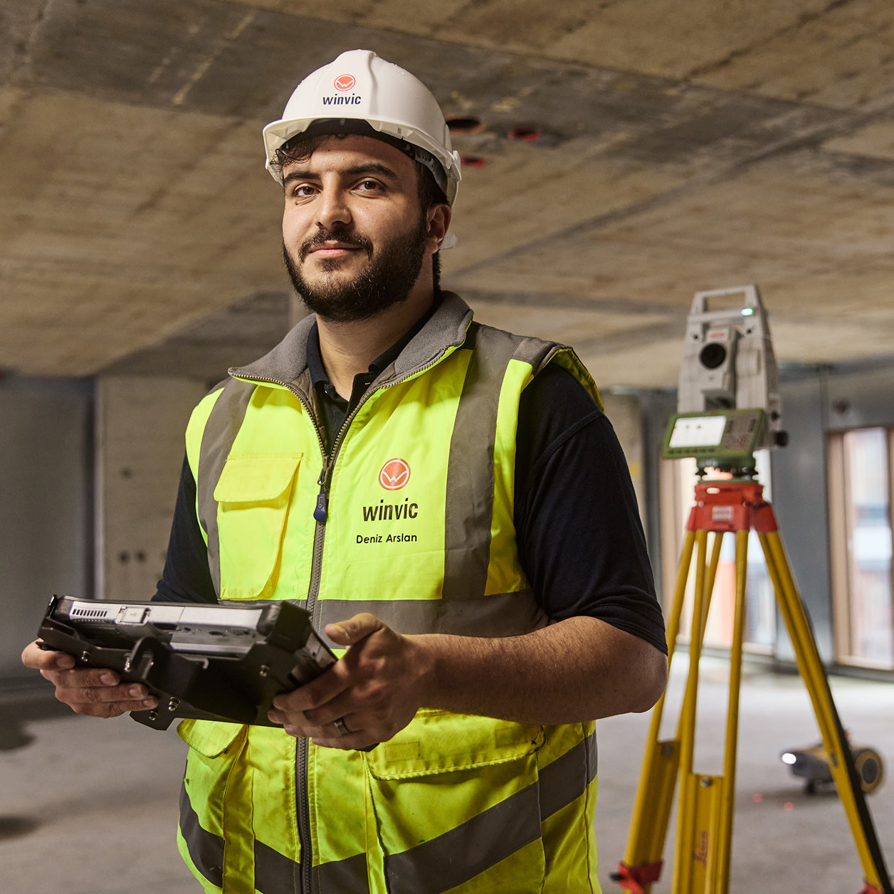 A construction worker smiling for the camera at a construction site