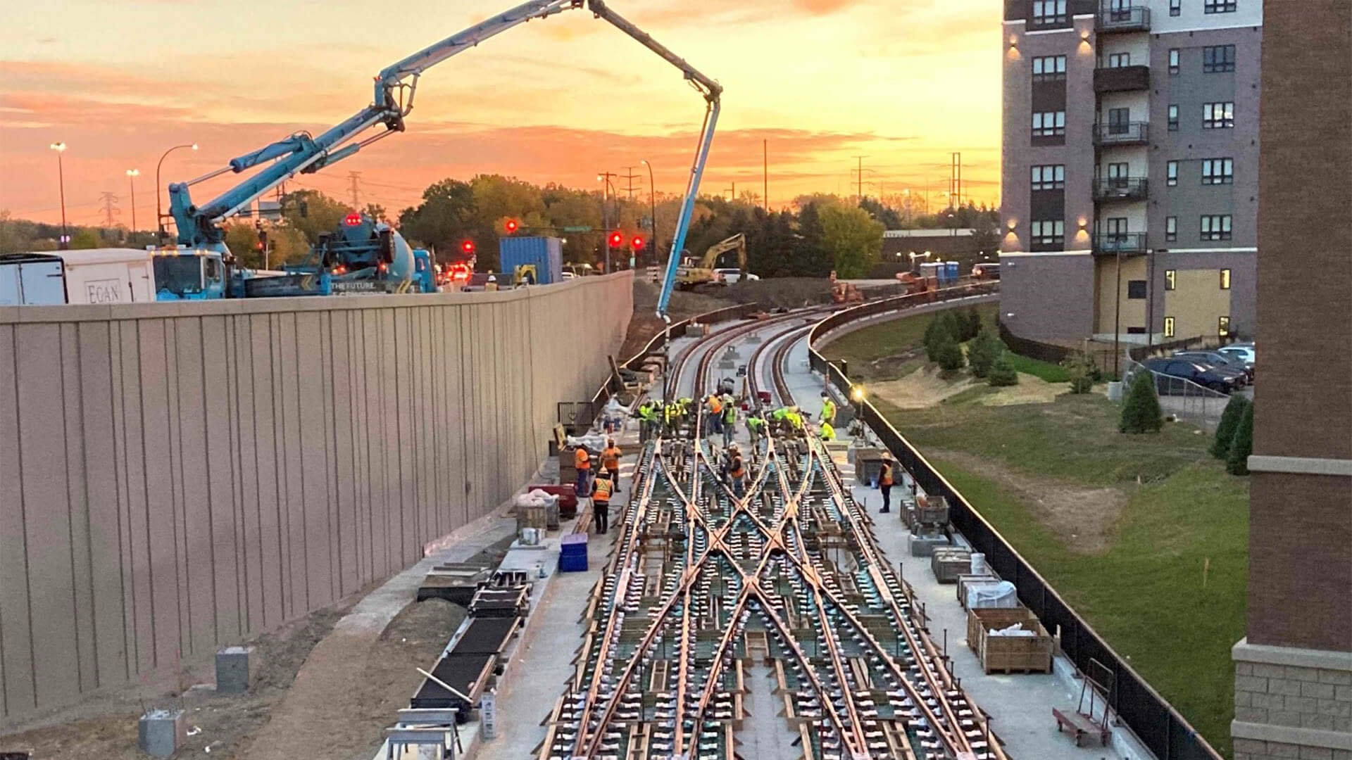 A railway under construction, with workers and cranes on site