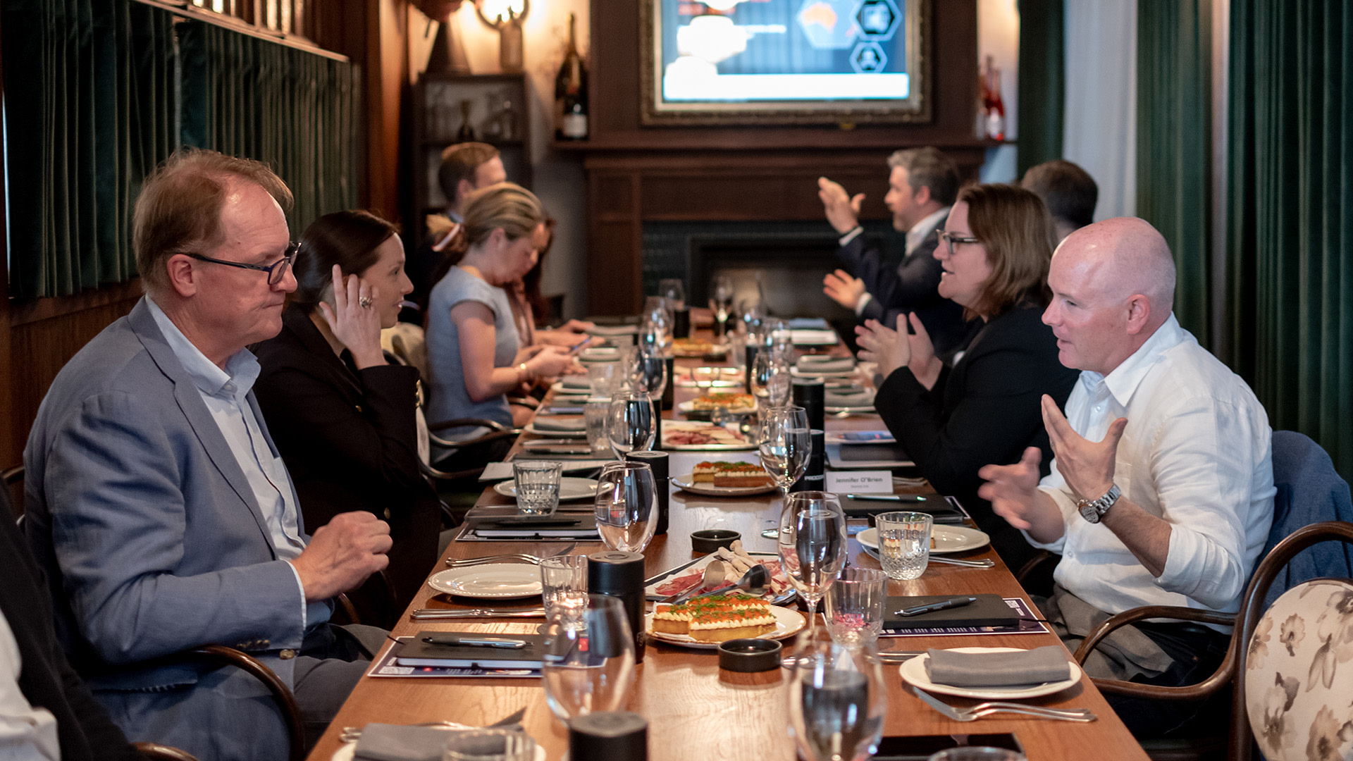 a group of people sitting at a long table