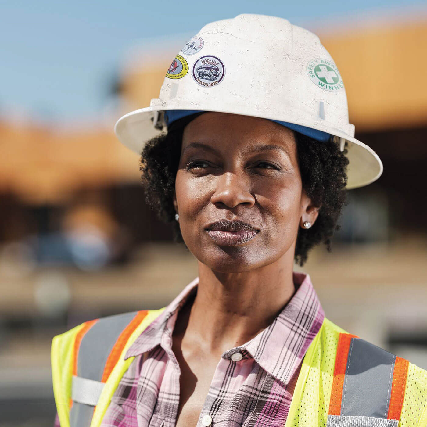 Construction worker standing outside looking into camera wearing ppe