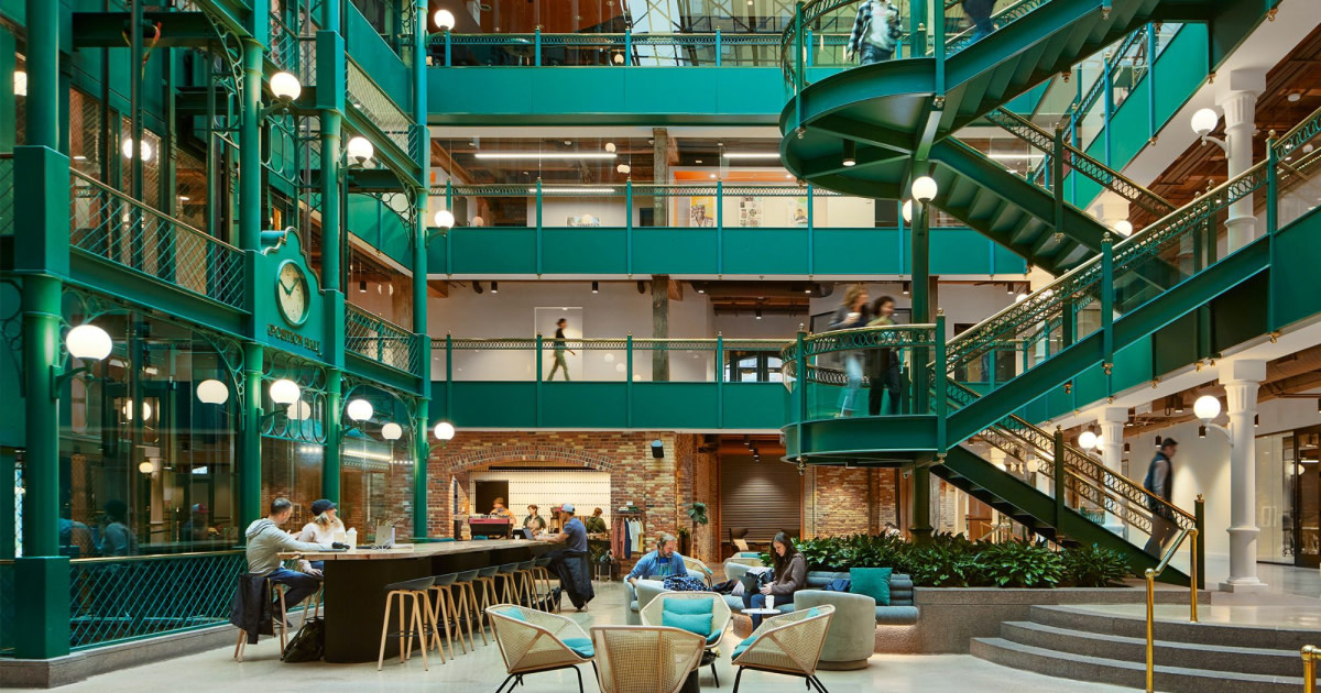 A mall's lobby with green stairs and aisles