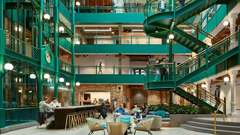 A mall's lobby with green stairs and aisles