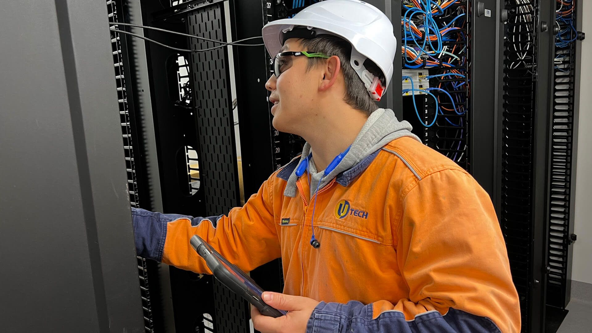Utech subcontractor checking cables in wiring cabinet